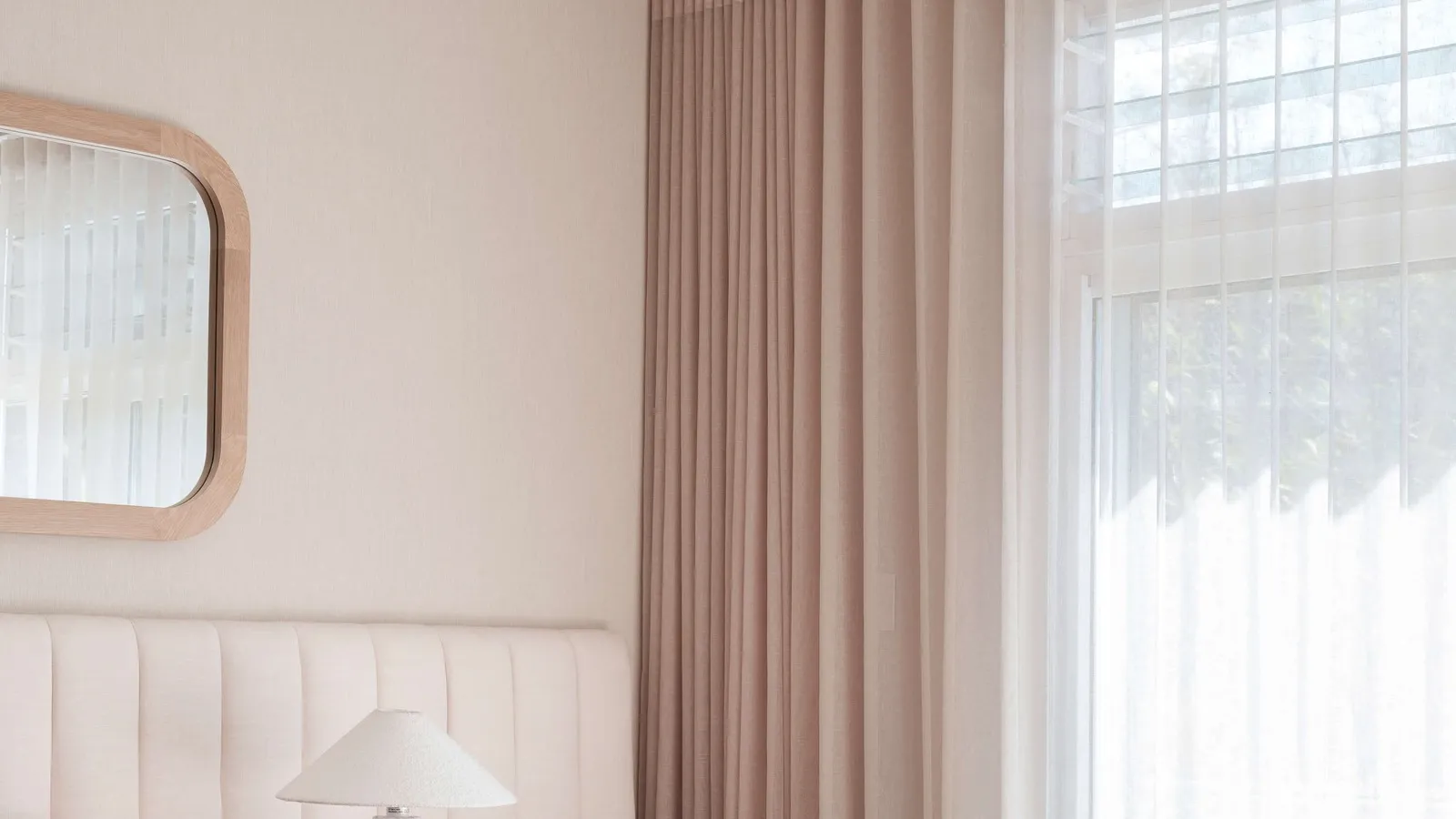 Layered blush curtains with a white sheer in a bedroom