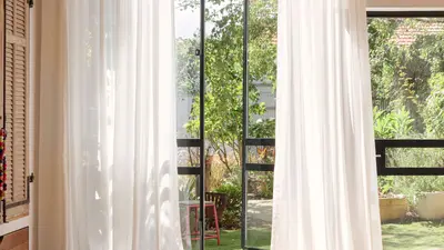 White wave-fold sheer curtains framing garden doors
