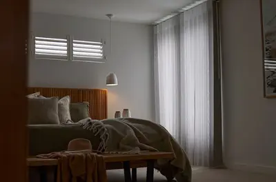 SmartDrape sheer vanes filtering soft evening light across a bedroom window