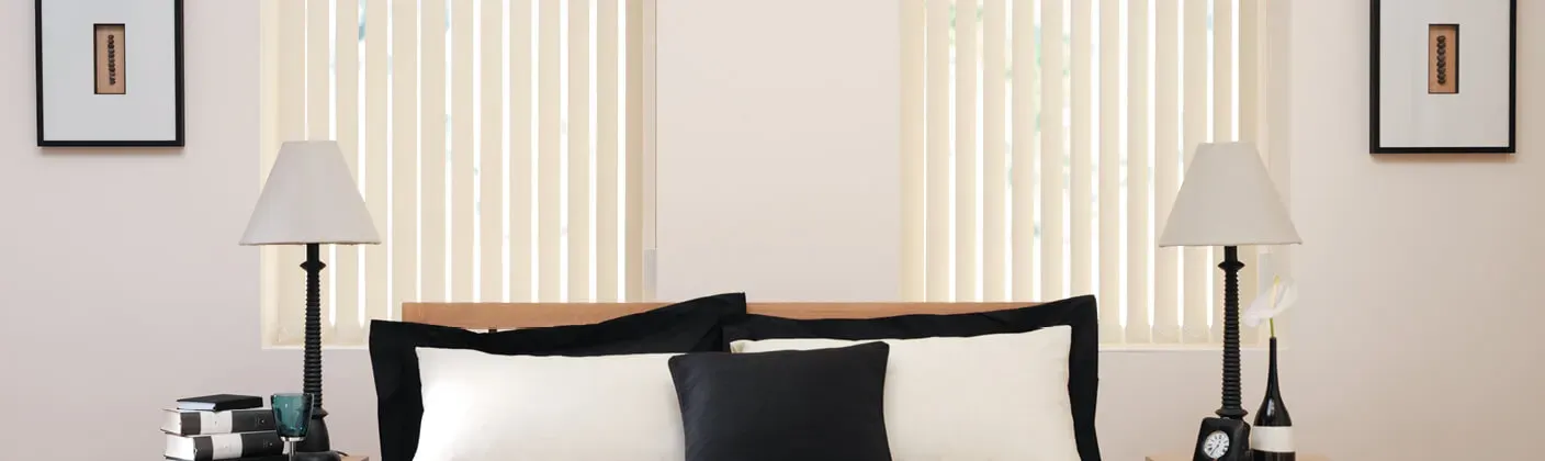 Fabric vertical blinds across wide bedroom windows
